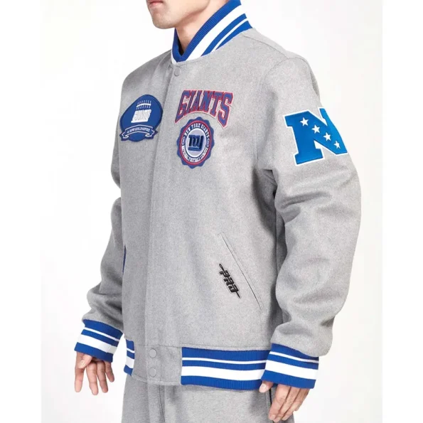 Model wearing NY Giants Crest Gray Varsity Jacket side view.