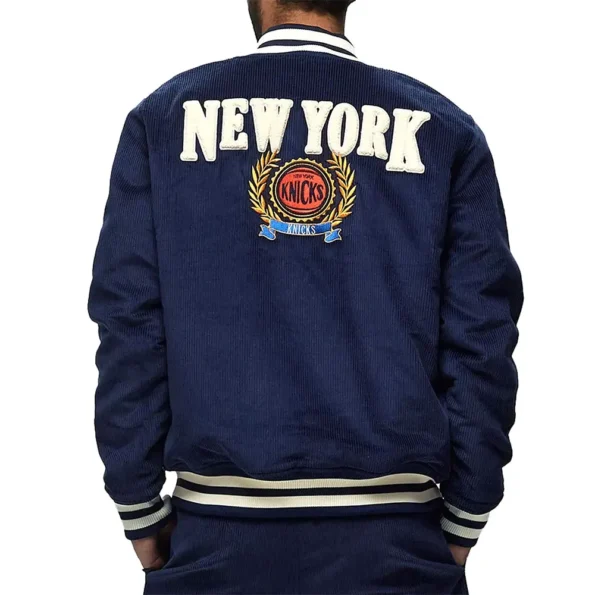 Model wearing NY Knicks Navy Corduroy Varsity Jacket back view.