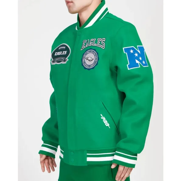 Side profile of model wearing Philadelphia Eagles Crest Varsity Jacket.