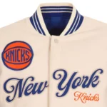 Front view NY Knicks cream and royal varsity jacket photo.